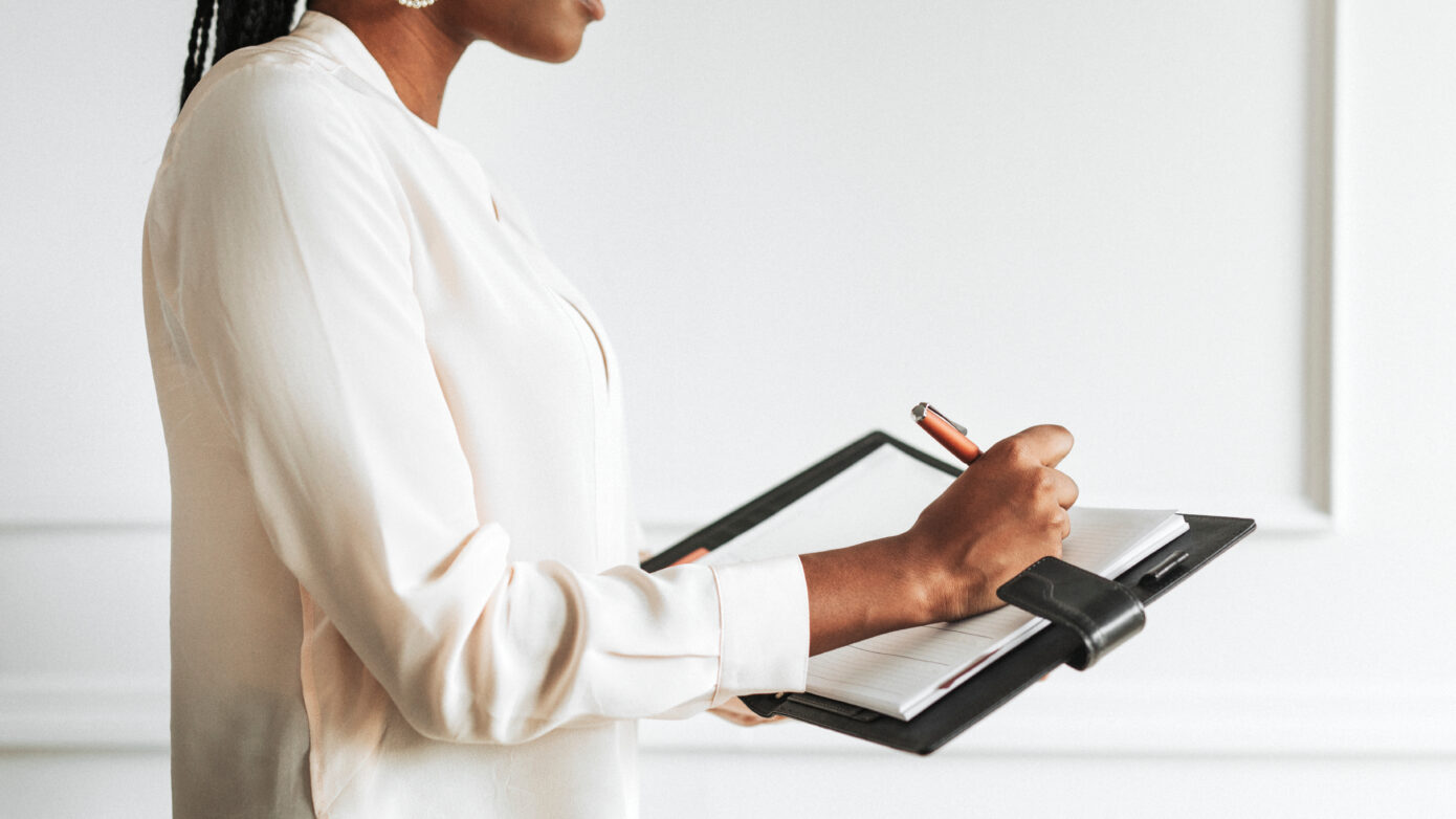 Businesswoman writing in a daily planner