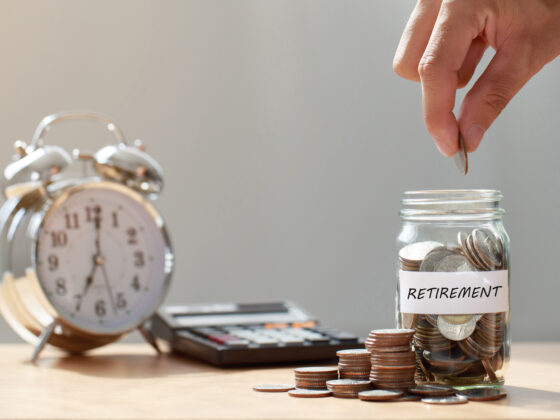 Hand putting coins into jar to save for retirement fund